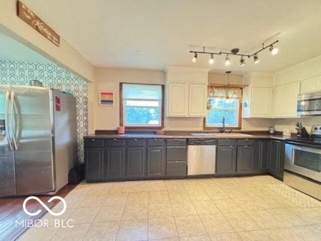 6546 Derbyshire Rd, Indianapolis, IN 46227 - kitchen featuring appliances with stainless steel finishes, white cabinets, dark countertops, and wallpapered walls