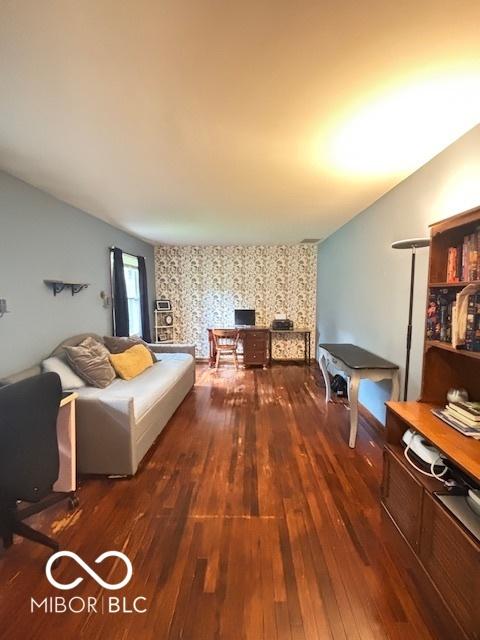 6546 Derbyshire Rd, Indianapolis, IN 46227 - living area featuring wallpapered walls, wood finished floors, a desk, and an accent wall