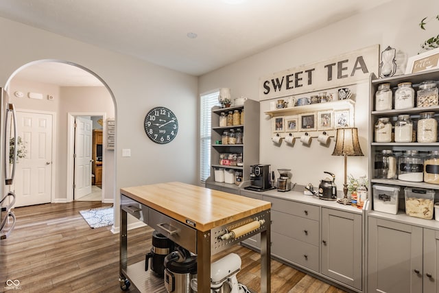 10585 Windward Dr, Indianapolis, IN 46234 - kitchen featuring arched walkways, gray cabinetry, open shelves, and light wood-type flooring
