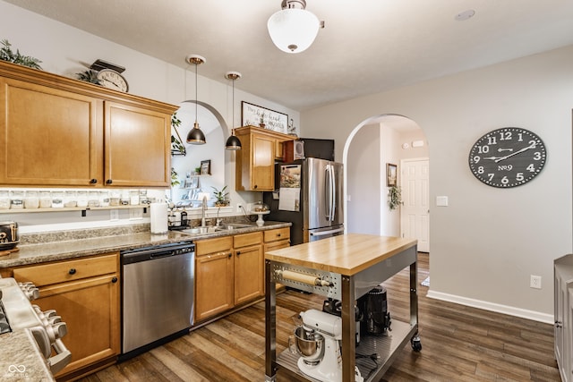 10585 Windward Dr, Indianapolis, IN 46234 - kitchen featuring appliances with stainless steel finishes, arched walkways, dark wood finished floors, and pendant lighting