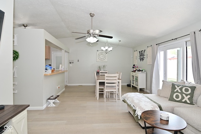 5936 Beau Jardin Dr, Indianapolis, IN 46237 - living area featuring lofted ceiling, light wood-style floors, a ceiling fan, a textured ceiling, and a chandelier