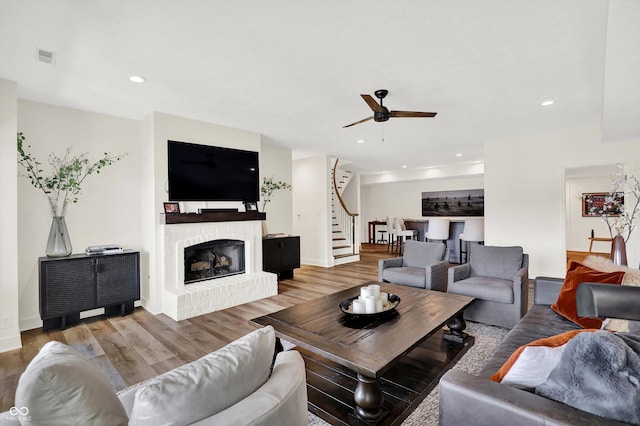 11137 Peppermill Ln, Fishers, IN 46037 - living room with stairs, ceiling fan, wood finished floors, a fireplace, and recessed lighting