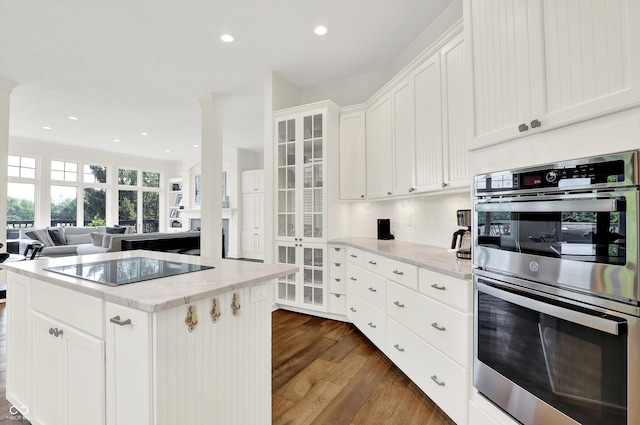 11137 Peppermill Ln, Fishers, IN 46037 - kitchen with double oven, black electric cooktop, dark wood-style floors, open floor plan, and white cabinets