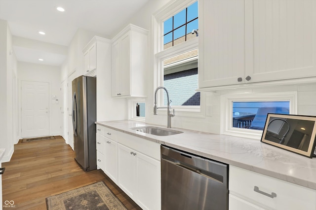 11137 Peppermill Ln, Fishers, IN 46037 - kitchen with stainless steel appliances, white cabinetry, wood finished floors, light stone countertops, and plenty of natural light