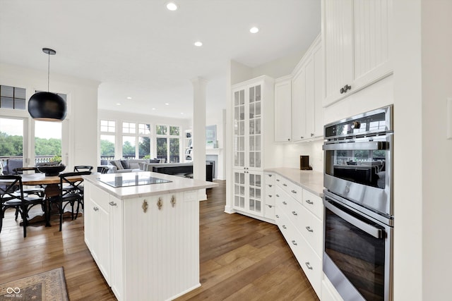 11137 Peppermill Ln, Fishers, IN 46037 - kitchen with double oven, black electric stovetop, a kitchen island, recessed lighting, and light countertops