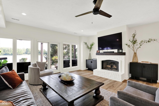 11137 Peppermill Ln, Fishers, IN 46037 - living area featuring a fireplace, a ceiling fan, light wood finished floors, and recessed lighting