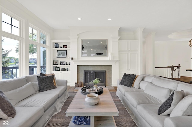 11137 Peppermill Ln, Fishers, IN 46037 - living area with built in features, recessed lighting, a tile fireplace, dark wood-style floors, and ornamental molding