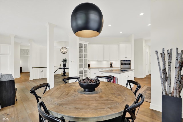 11137 Peppermill Ln, Fishers, IN 46037 - dining space featuring light wood-style flooring, decorative columns, and recessed lighting