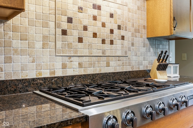 20136 Stone Church Rd, Laurel, IN 47024 - kitchen view of stove, dark countertops, tasteful backsplash, and brown cabinetry