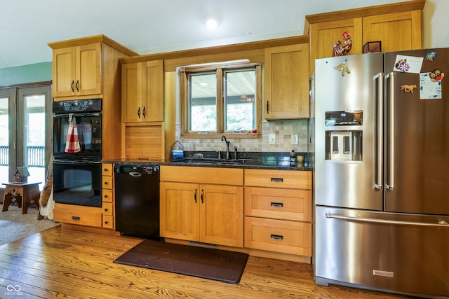 20136 Stone Church Rd, Laurel, IN 47024 - kitchen with black appliances, light wood finished floors, backsplash, and dark stone countertops