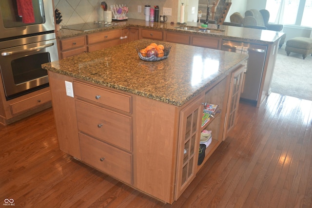 10166 Ranford Blvd, Fishers, IN 46040 - kitchen featuring stainless steel appliances, a peninsula, hardwood / wood-style flooring, and dark stone counters