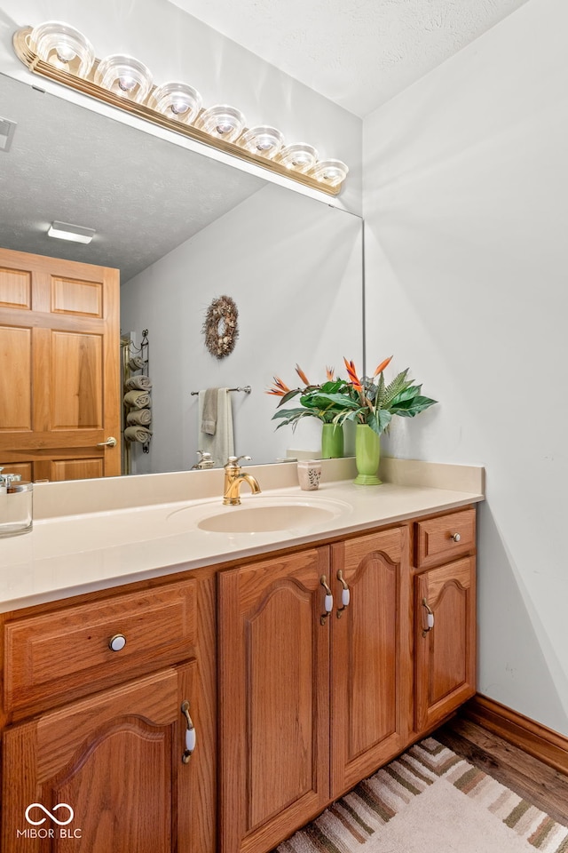 2320 Whispering Way, Indianapolis, IN 46239 - bathroom featuring vanity, a textured ceiling, and wood finished floors