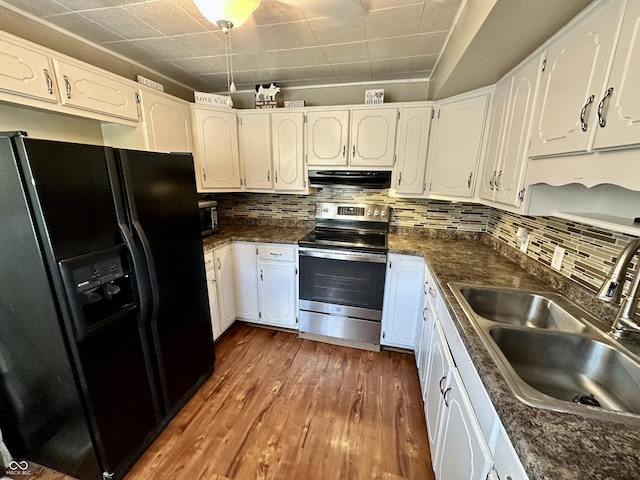 329 S Lockburn St, Indianapolis, IN 46241 - kitchen with black fridge with ice dispenser, stainless steel electric stove, under cabinet range hood, wood-type flooring, and dark countertops