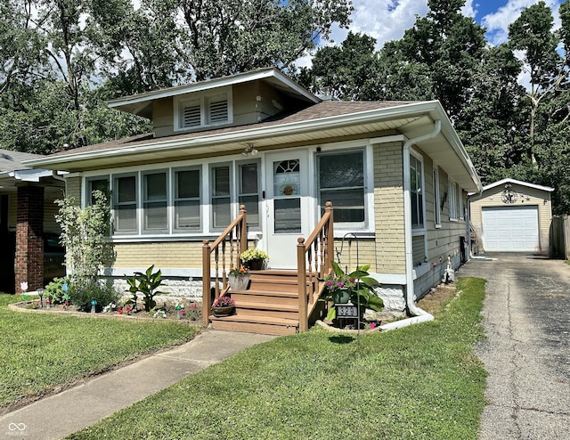 329 S Lockburn St, Indianapolis, IN 46241 - bungalow-style home featuring driveway, an outbuilding, a front yard, a detached garage, and brick siding