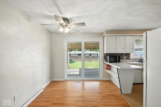 3504 White River Ct, Anderson, IN 46012 - kitchen featuring freestanding refrigerator, stainless steel microwave, white cabinets, ceiling fan, and light countertops