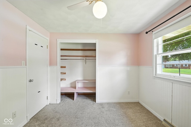 3504 White River Ct, Anderson, IN 46012 - unfurnished bedroom featuring wainscoting, carpet floors, a closet, baseboard heating, and ceiling fan