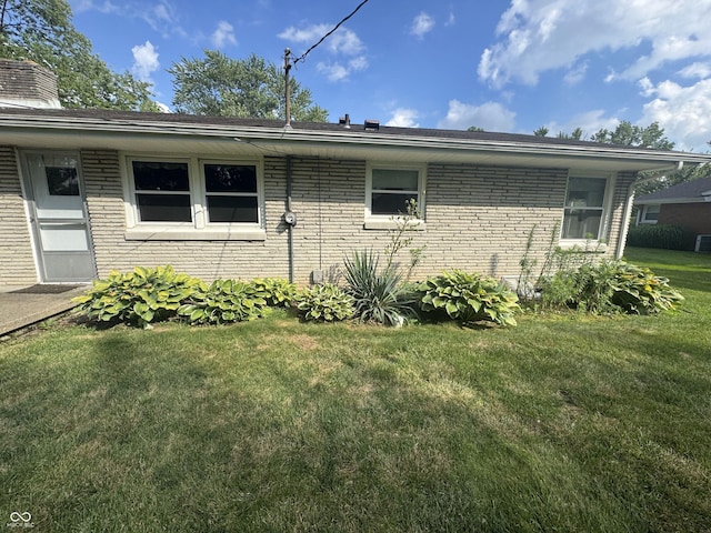 4032 Roselawn Ave, Columbus, IN 47203 - view of side of property with brick siding, a lawn, and a chimney