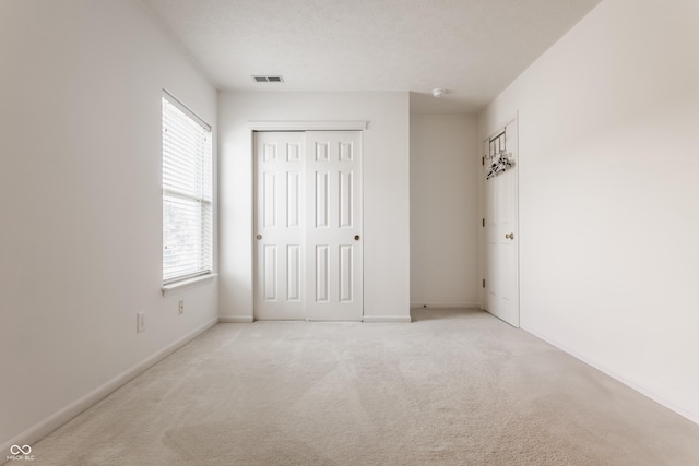 13390 Grosbeak Ct, Carmel, IN 46033 - unfurnished bedroom with multiple windows, light carpet, and a closet