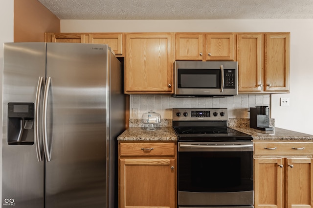 13390 Grosbeak Ct, Carmel, IN 46033 - kitchen with appliances with stainless steel finishes, backsplash, light stone counters, and a textured ceiling