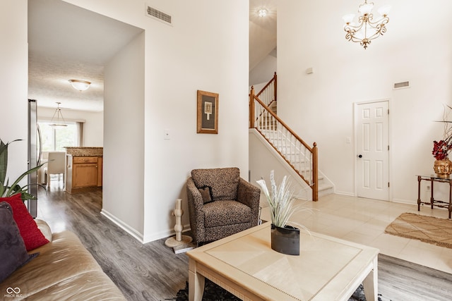 13390 Grosbeak Ct, Carmel, IN 46033 - living room with stairway, a towering ceiling, light wood-style flooring, and a chandelier