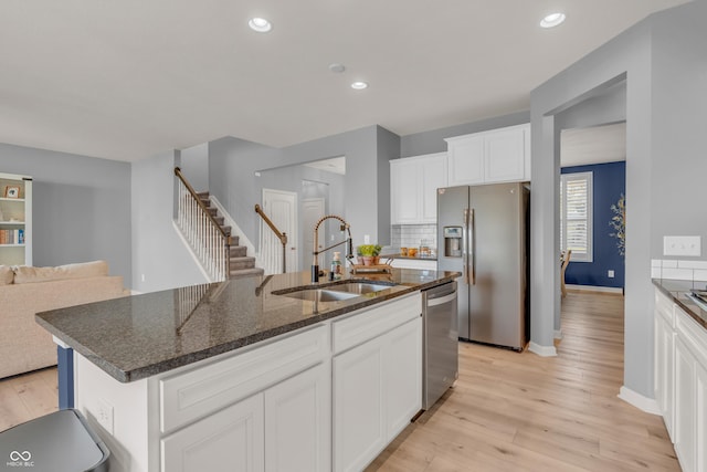 5353 Hibiscus Dr, Plainfield, IN 46168 - kitchen with appliances with stainless steel finishes, light wood finished floors, backsplash, a kitchen island with sink, and recessed lighting