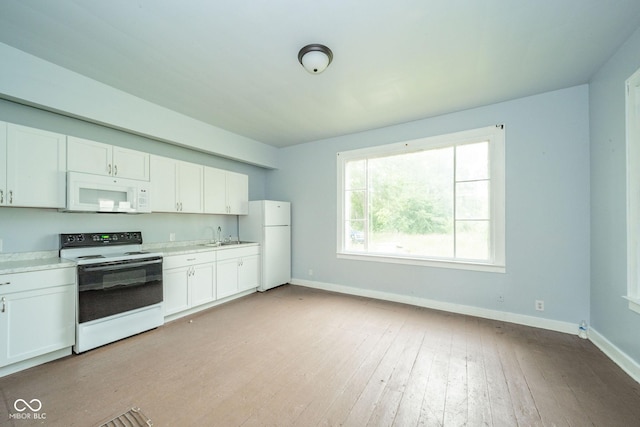 2627 Chase St, Anderson, IN 46016 - kitchen featuring white appliances, white cabinetry, light countertops, and light wood-style flooring