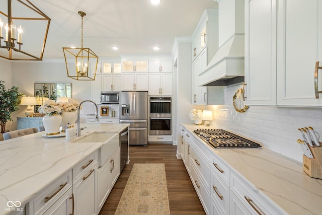 2566 Maple Creek Dr, Westfield, IN 46074 - kitchen featuring appliances with stainless steel finishes, a chandelier, premium range hood, white cabinetry, and decorative backsplash