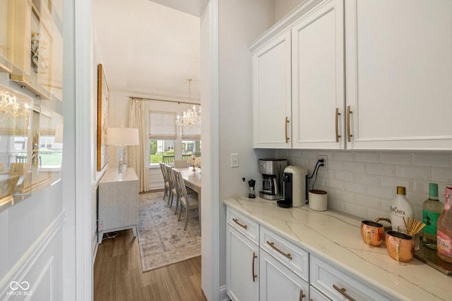 2566 Maple Creek Dr, Westfield, IN 46074 - kitchen featuring a chandelier, white cabinetry, tasteful backsplash, and wood finished floors
