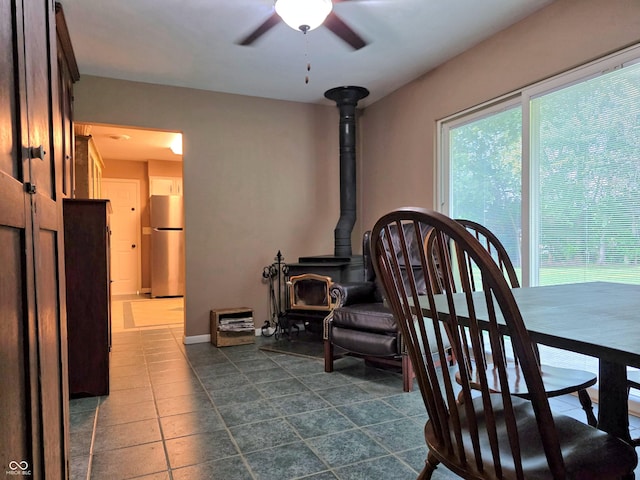 3303 N 850 E, Columbus, IN 47203 - dining area with a ceiling fan, a wood stove, and dark tile patterned flooring