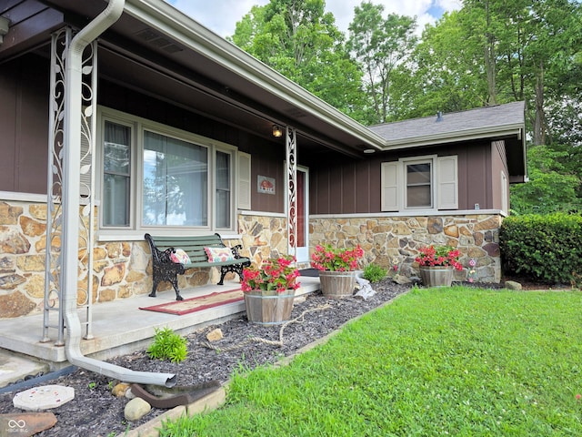 3303 N 850 E, Columbus, IN 47203 - view of front of house featuring stone siding, covered porch, a front yard, and board and batten siding