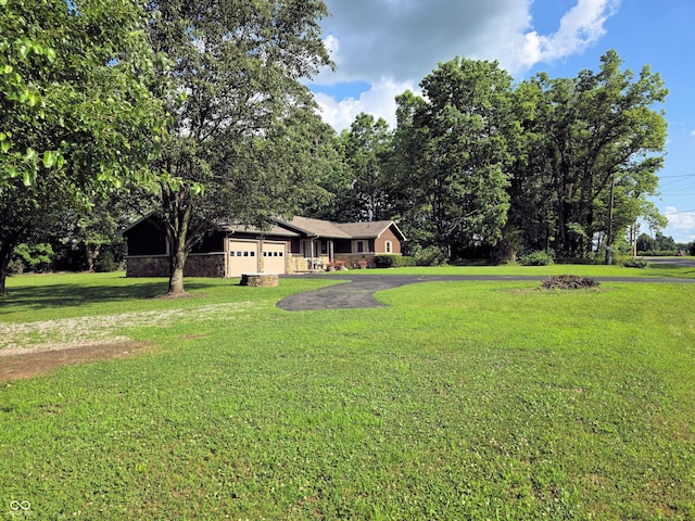 3303 N 850 E, Columbus, IN 47203 - view of grassy yard featuring asphalt driveway and a garage