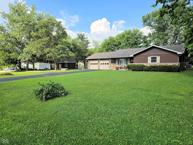 3303 N 850 E, Columbus, IN 47203 - ranch-style home with an attached garage, asphalt driveway, and a front yard