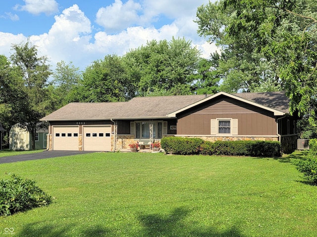 3303 N 850 E, Columbus, IN 47203 - single story home with stone siding, a garage, a front lawn, and asphalt driveway