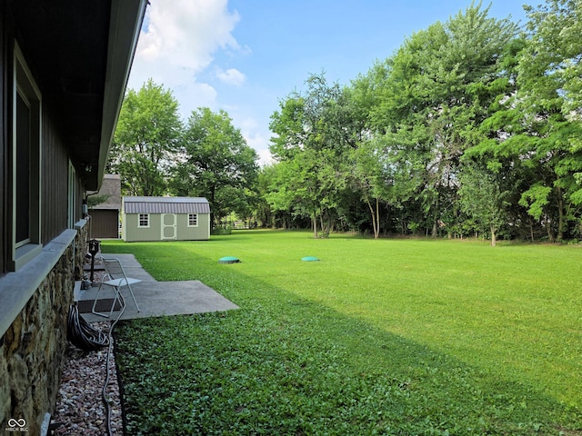 3303 N 850 E, Columbus, IN 47203 - view of green lawn featuring a patio area, an outbuilding, and view of wooded area