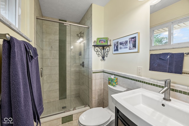 624 Cumberland Ave, West Lafayette, IN 47906 - full bath featuring vanity, tile walls, a shower stall, a wainscoted wall, and tile patterned floors