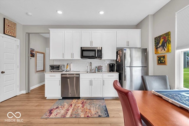 5345 Ridgecrest Ln, Mccordsville, IN 46055 - kitchen with stainless steel appliances, light wood-style floors, white cabinetry, decorative backsplash, and recessed lighting