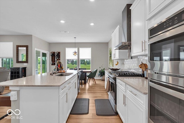 5345 Ridgecrest Ln, Mccordsville, IN 46055 - kitchen featuring stainless steel appliances, wall chimney range hood, light wood-style flooring, white cabinetry, and recessed lighting