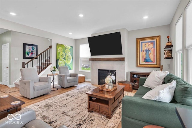 5345 Ridgecrest Ln, Mccordsville, IN 46055 - living room featuring stairway, healthy amount of natural light, wood finished floors, a tiled fireplace, and recessed lighting