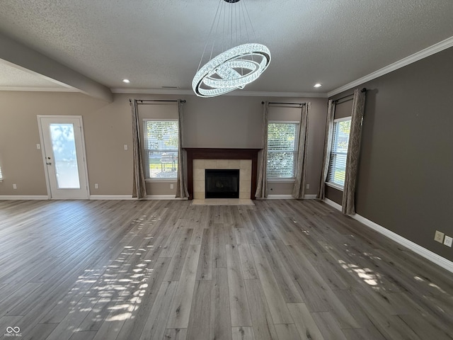 14171 Refreshing Garden Ln, Fishers, IN 46038 - unfurnished living room with a textured ceiling, wood finished floors, ornamental molding, recessed lighting, and a chandelier