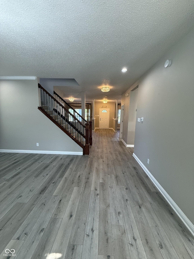 14171 Refreshing Garden Ln, Fishers, IN 46038 - unfurnished living room with stairway, a textured ceiling, and wood finished floors
