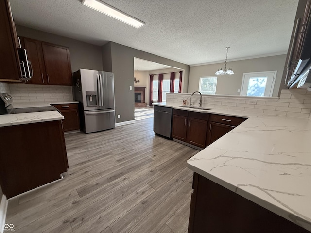 14171 Refreshing Garden Ln, Fishers, IN 46038 - kitchen with appliances with stainless steel finishes, tasteful backsplash, a textured ceiling, a peninsula, and a chandelier