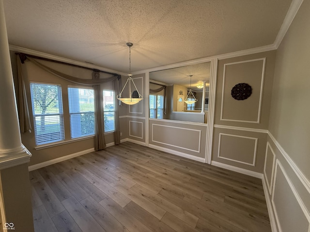 14171 Refreshing Garden Ln, Fishers, IN 46038 - unfurnished dining area with a decorative wall, a textured ceiling, ornamental molding, and wood finished floors