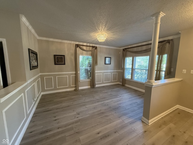 14171 Refreshing Garden Ln, Fishers, IN 46038 - unfurnished room with decorative columns, ornamental molding, healthy amount of natural light, wood finished floors, and a textured ceiling