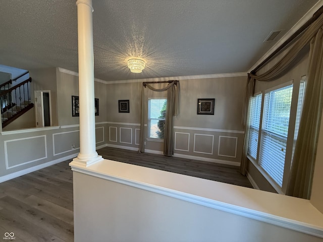 14171 Refreshing Garden Ln, Fishers, IN 46038 - interior space with wood finished floors, ornate columns, crown molding, a decorative wall, and a wainscoted wall