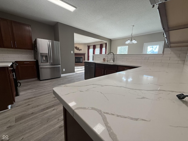 14171 Refreshing Garden Ln, Fishers, IN 46038 - kitchen with stainless steel fridge, decorative backsplash, dishwashing machine, light stone counters, and a textured ceiling