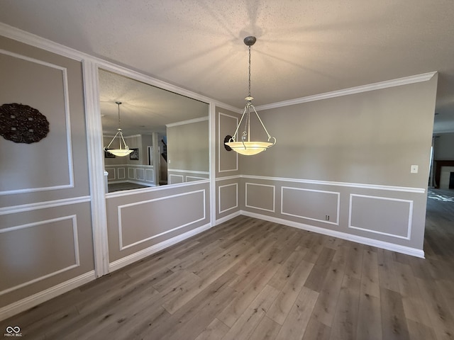 14171 Refreshing Garden Ln, Fishers, IN 46038 - unfurnished dining area featuring a decorative wall, wood finished floors, crown molding, and wainscoting