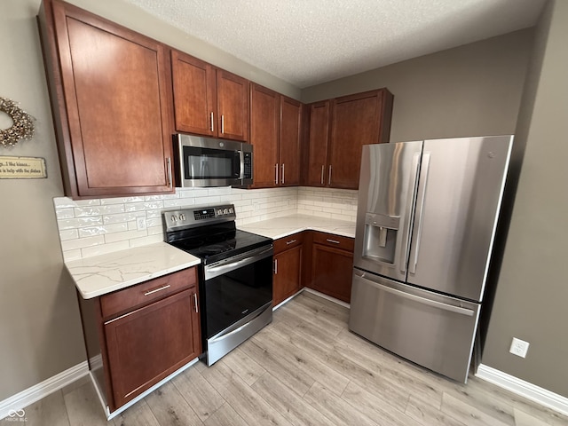 14171 Refreshing Garden Ln, Fishers, IN 46038 - kitchen featuring appliances with stainless steel finishes, light wood-type flooring, backsplash, and a textured ceiling