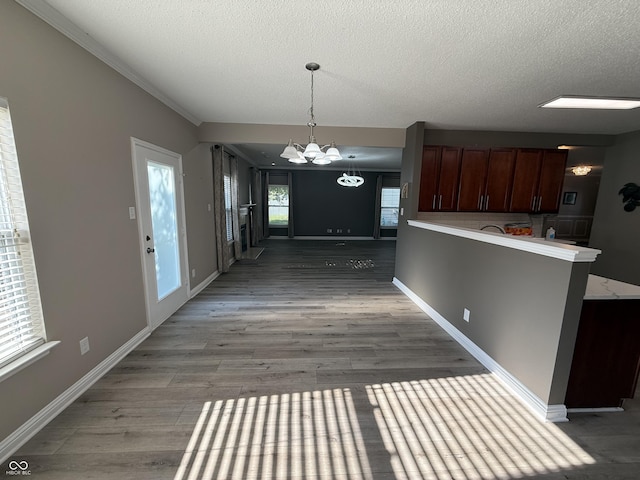 14171 Refreshing Garden Ln, Fishers, IN 46038 - kitchen with a textured ceiling, a chandelier, light wood-type flooring, light countertops, and a peninsula