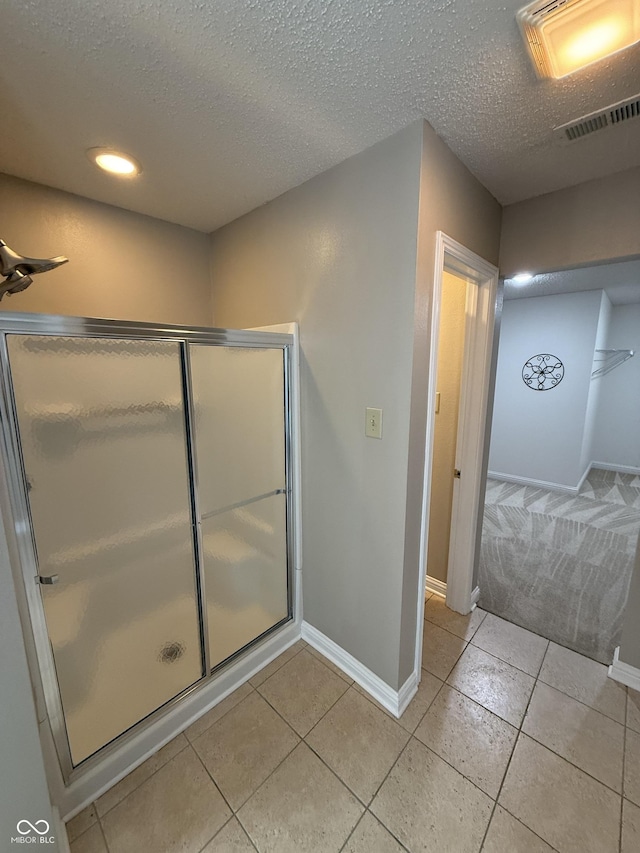 14171 Refreshing Garden Ln, Fishers, IN 46038 - bathroom featuring tile patterned floors, a shower stall, a textured ceiling, and recessed lighting