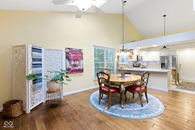 1114 Clairborne Ct, Indianapolis, IN 46280 - dining room with high vaulted ceiling, a ceiling fan, light wood-style flooring, and a chandelier